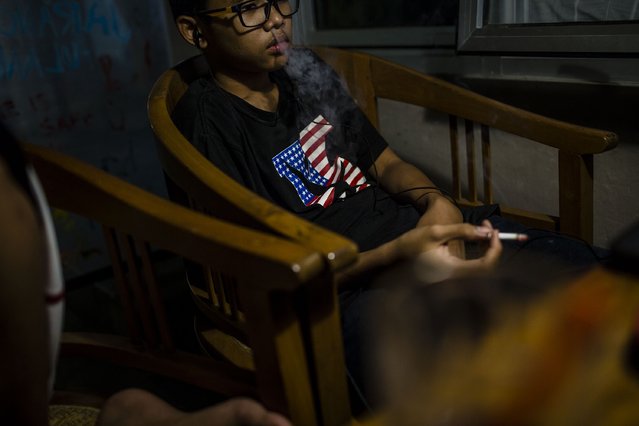 Salman (16), smokes at a coffee shop with his friends on March 7, 2017 in Yogyakarta, Indonesia. (Photo by Ulet Ifansasti/Getty Images)