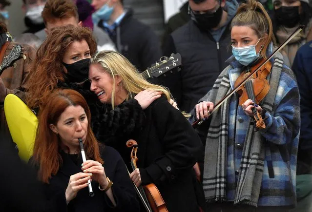 A musician reacts during the funeral of late 23-year-old teacher, Ashling Murphy, who was murdered while out jogging, outside the St Brigid's Church in Mountbolus near Tullamore, Ireland on January 18, 2022. (Photo by Clodagh Kilcoyne/Reuters)
