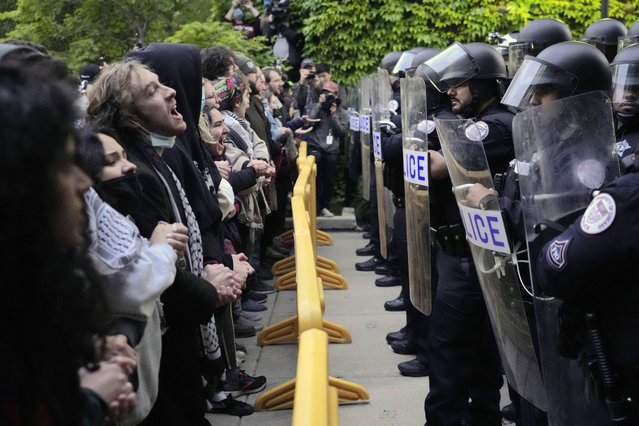 Pro-Palestinian protesters chant at University of Chicago police while being kept from the university's quad as the student encampment is dismantled Tuesday, May 7, 2024, in Chicago. (Photo by Charles Rex Arbogast/AP Photo)