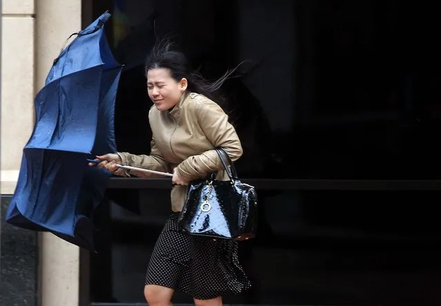 A woman is caught in the wind and rain as a cold front moves into Houston, on April 14, 2014. The cold front has brought snow to the Texas Panhandle, hail to the central part of the state and forecasts for freezing conditions accompanied by strong winds. (Photo by Mayra Beltran/Houston Chronicle)
