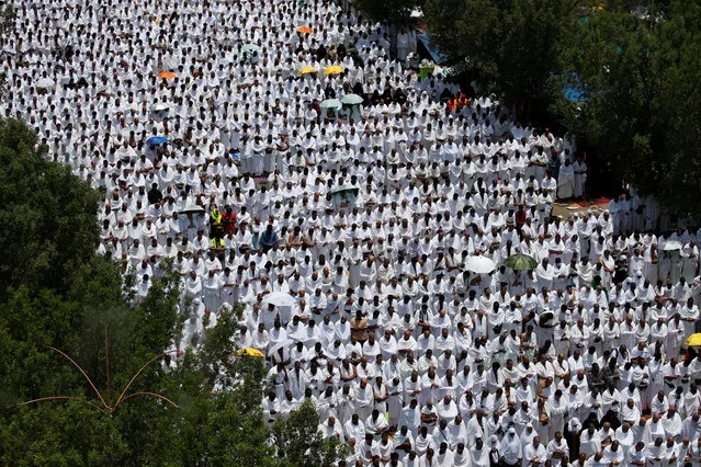Muslim pilgrims pray outside Namira Mosque on the plains of Arafat during the annual haj pilgrimage, outside the holy city of Mecca, Saudi Arabia on August 10, 2019. (Photo by Umit Bektas/Reuters)