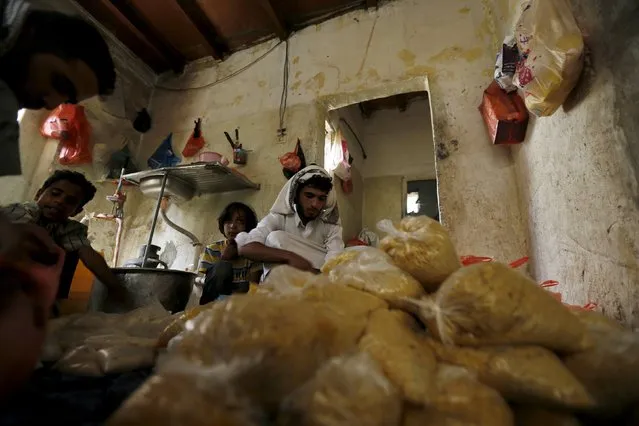 Volunteers prepare rations at a charity food assistance center they run in Yemen's capital Sanaa July 1, 2015. (Photo by Khaled Abdullah/Reuters)