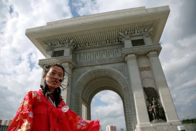 A guide wearing a traditional dress speaks to visitors at the Arch of Triumph in Pyongyang, North Korea May 4, 2016. (Photo by Damir Sagolj/Reuters)