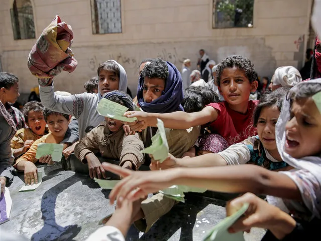 Yemenis present documents in order to receive food rations provided by a local charity, in Sanaa, Yemen, Thursday, April, 13, 2017. A Saudi-led coalition launched a campaign in support of Yemen's internationally recognized government in March 2015. The stalemated war has pushed the Arab world's poorest country to the brink of famine. (Photo by Hani Mohammed/AP Photo)