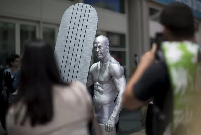 A cosplay enthusiast dressed like the character Silver Surfer poses for photos during the 2015 Comic-Con International Convention in San Diego, California July 10, 2015. (Photo by Mario Anzuoni/Reuters)