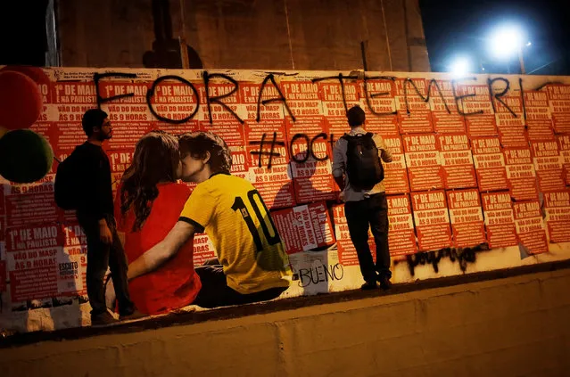 A member of Brazil's Homeless Workers' Movement (MTST) write a phrase that reads “Out Temer” on a wall, after the Brazilian Senate voted to impeach President Dilma Rousseff, at Paulista Avenue in Sao Paulo, Brazil, May 12, 2016. (Photo by Nacho Doce/Reuters)