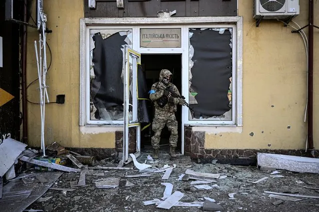 A Ukrainian serviceman exits a damaged building after shelling in Kyiv, on March 11, 2022. Russian forces are positioned around Kiev on March 12, 2022 and are “blocking” Mariupol, where thousands of people are suffering a devastating siege, in southern Ukraine, a country that has been bombed for more than two weeks. (Photo by Aris Messinis/AFP Photo)