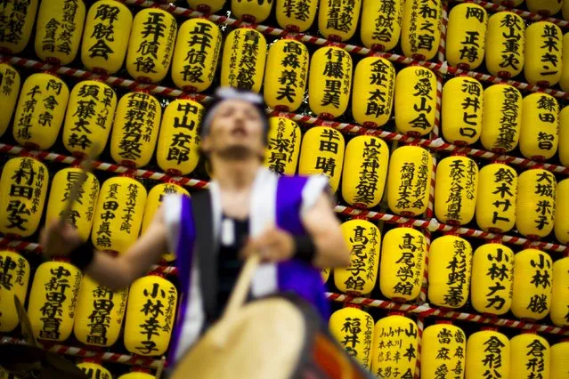 A man beats a drum in front of a wall of lanterns during the annual Mitama Festival at the Yasukuni Shrine in Tokyo, Japan, July 13, 2015. Over 30,000 lanterns light up the precincts of the shrine, where more than 2.4 million war dead are enshrined, during the four-day festival from July 13 to 16. (Photo by Thomas Peter/Reuters)