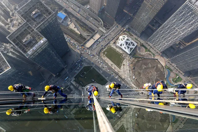 Skyscraper window cleaners clean the exterior of Guiyang International Trade Center in Guiyang, southwest China's Guizhou Province, March 15, 2022. The 335-meter-high twin skyscrapers of Guiyang International Trade Center recently saw their first exterior wall cleaning this year. The cleaning, carried out by eight workers, is expected to take about 20 days. (Photo by  Ou Dongqu/Xinhua/Alamy Live News)