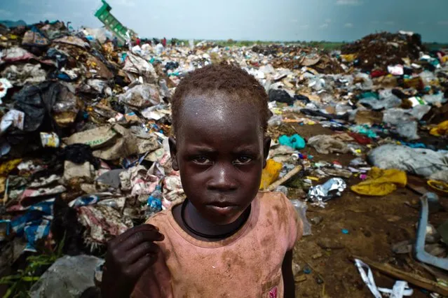 A picture taken on August 1, 2012 shows a young Sudanese posing at a rubbish dump in the South Sudanese capital, Juba. The increase of prices in South Sudan makes life very difficult for south sudanese people, some of them have no other choice but to pick up food or find and sell iron from rubbish dump areas. (Photo by Camille Lepage/AFP Photo)