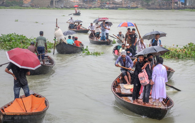 People hold umbrellas as they cross the Buriganga River on boats during a rainy day in Dhaka, Bangladesh, 26 June 2024. The Bangladesh Meteorological Department (BMD) has issued a weather forecast for Bangladesh, predicting light to moderate rainfall with gusty winds. The summer monsoon season in Bangladesh is observed from June through mid-October. (Photo by Monirul Alam/EPA)