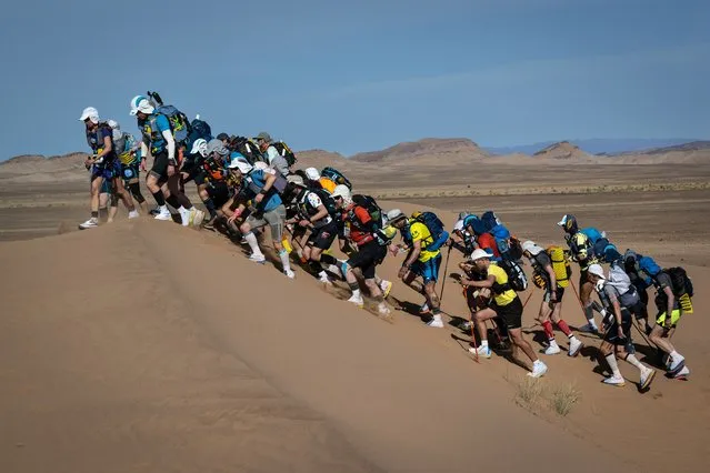 Competitors take part in the Stage 2 of the 36th edition of the Marathon des Sables between Ouest Aguenoun n'Oumerhiout and Rich Mbirika in the Moroccan Sahara desert, central Morocco, on March 28, 2022. The 36th edition of the marathon is a live stage 250 kilometres race through a formidable landscape in one of the world's most inhospitable climates. (Photo by Jean-Philippe Ksiazek/AFP Photo)
