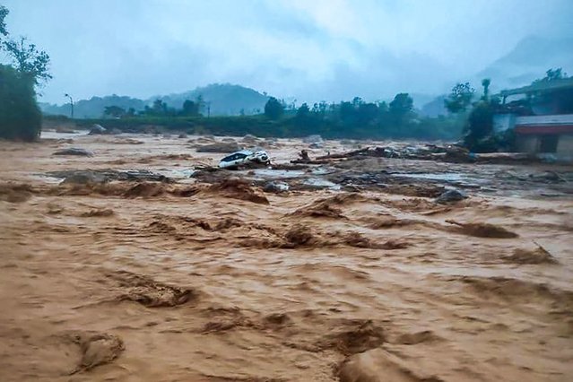 This handout photograph taken on July 30, 2024 and released by India's National Disaster Response Force (NDRF) shows a damaged car at the landslide site in Wayanad. The southern coastal state of Kerala has been battered by torrential downpours, and the collapse of a key bridge at the disaster site in Wayanad district has hampered rescue efforts, according to local media reports. (Photo by National Disaster Response Force (NDRF)/AFP Photo)