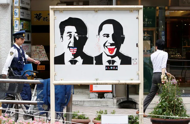 Police officers walk behind a sticker art depicting Japan's Prime Minister Shinzo Abe (L) and U.S. President Barack Obama as they patrol in Tokyo's Shibuya shopping district, as part of increased security measures during the Ise-Shima G7 summit, in Japan May 26, 2016. (Photo by Yuya Shino/Reuters)