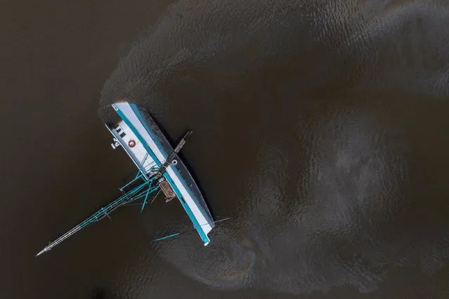 Fuel leaks from a capsized boat along Bayou Lafourche in the aftermath of Hurricane Ida in Galliano, Louisiana, U.S., August 31, 2021. Picture taken with a drone. (Photo by Adrees Latif/Reuters)