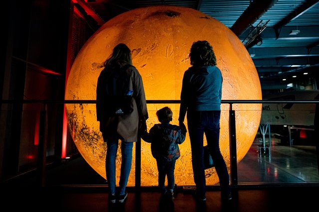 A family admire artist Luke Jerram's Mars installation at Aerospace Bristol, as part of a new Journey to Mars exhibition on Thursday, May 4, 2023. The temporary exhibition marks the 20th anniversary of Mars Express, Europe's first mission to Mars, with models of the Mars Express Orbiter and the Beagle 2 lander on display alongside artist's Mars sculpture. (Photo by Ben Birchall/PA Images via Getty Images)