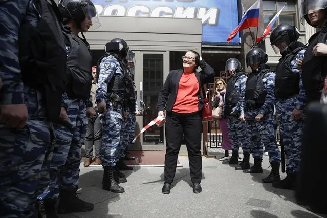 Protester Yuliya Galyamina, center, speaks to the police during a rally against a Moscow City's project to pull down Soviet-era apartment blocks outside the Kremlin in front of the state Parliament building in Moscow, Russia, Friday, June 9, 2017. About 300 people rallied outside the Russian parliament on Friday morning to protest a controversial plan to tear down Soviet-era low-rise apartment blocks. (Photo by Pavel Golovkin/AP Photo)