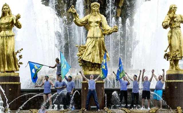 Former Russian paratroopers celebrate Paratroopers' Day in the Friendship of Nations fountain, in Moscow, Russia, Sunday, August 2, 2015. (Photo by Pavel Golovkin/AP Photo)
