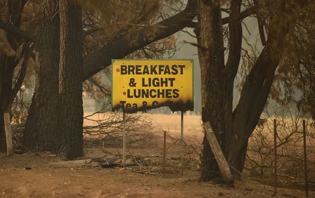 A sign is seen half burnt after bushfires ravaged the town of Bilpin, 70km west of Sydney on December 29, 2019. A heatwave is due to sweep across parts of New South Wales in the coming days, with deteriorating bushfire conditions expected to hit on New Years Eve on December 31. (Photo by Peter Parks/AFP Photo)