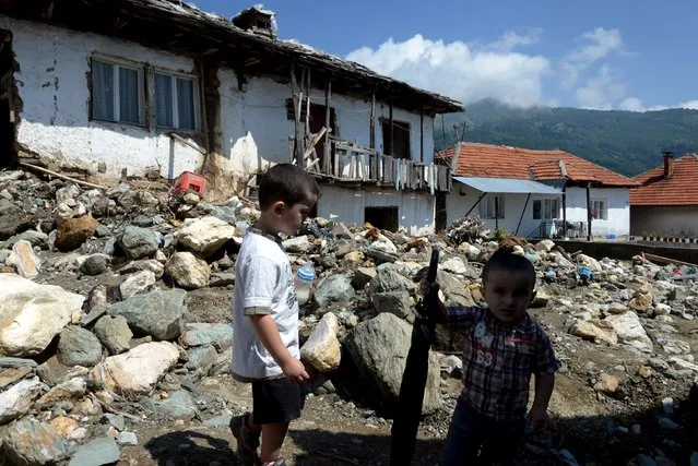 Boys stand on a street in the flooded village of Shipkovitsa, near the town of Tetovo, Macedonia, August 4, 2015. (Photo by Reuters/Stringer)