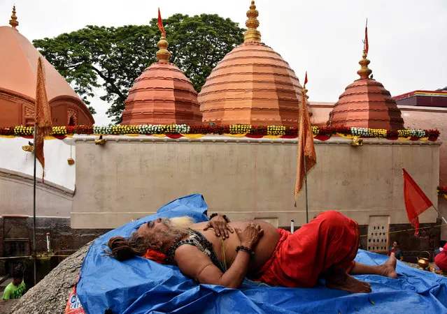 A Sadhu or a Hindu holy man sleeps inside the Kamakhya temple during the annual Hindu festival of Ambubachi, a celebration of what is believed to be the menstruation cycle of the goddess Kamakhya, in Guwahati,June 22, 2017. (Photo by Anuwar Hazarika/Reuters)