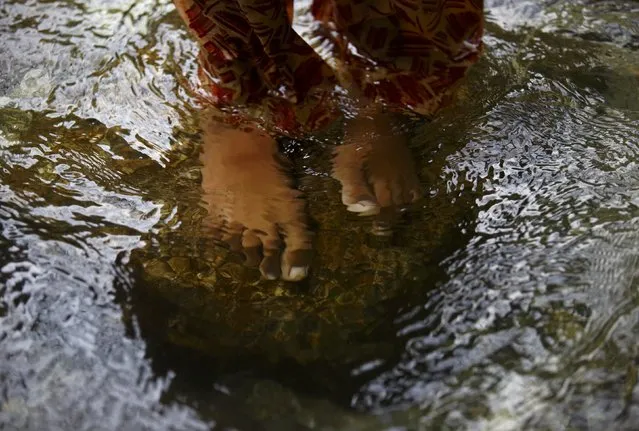 The bare feet of a Hindu devotee are pictured underwater as she stands on Bagmati River while offering prayers during the “Bol Bom” pilgrimage in Kathmandu August 10, 2015. (Photo by Navesh Chitrakar/Reuters)