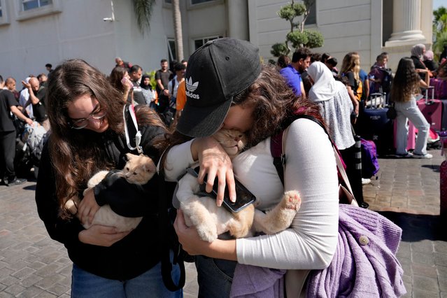 Turkish citizens carry their cats as they wait to board a Turkish navy vessel to be evacuated to Turkey at a gathering point, in Beirut, Lebanon, Wednesday, October 9, 2024. (Photo by Hussein Malla/AP Photo)