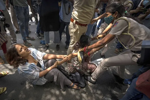 Police officers try to detain students and activists during a protest demonstration against a new short-term government recruitment scheme for the military, in New Delhi, India, Friday, June 17, 2022. Hundreds of angry youths gave vent to their ire by burning train coaches, vandalizing railroad property and blocking rail tracks and highways with boulders as a backlash continued for a second straight day Friday against a new short-term government recruitment scheme for the military. Nearly 500 protesters vastly outnumbered policemen as they went on a rampage for more than an hour at Secundrabad railroad station in southern India. (Photo by Altaf Qadri/AP Photo)