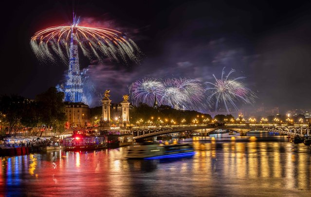 Fireworks explode next to the Eiffel Tower and the Seine river as part of the annual Bastille Day celebrations in Paris, on July 14, 2023. (Photo by Bertrand Guay/AFP Photo)