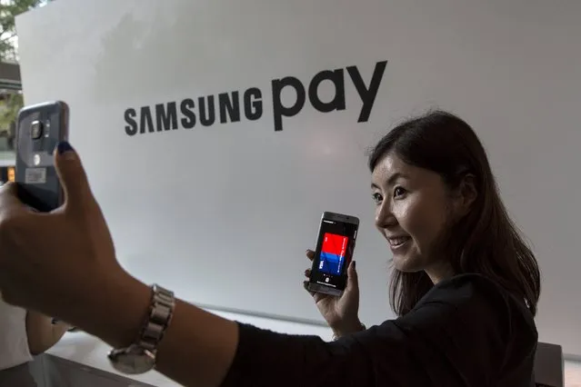 A woman takes a “selfie” with a Samsung Galaxy S6 Edge+ near the Samsung Pay display at the Samsung Galaxy Unpacked 2015 event in New York August 13, 2015. (Photo by Andrew Kelly/Reuters)