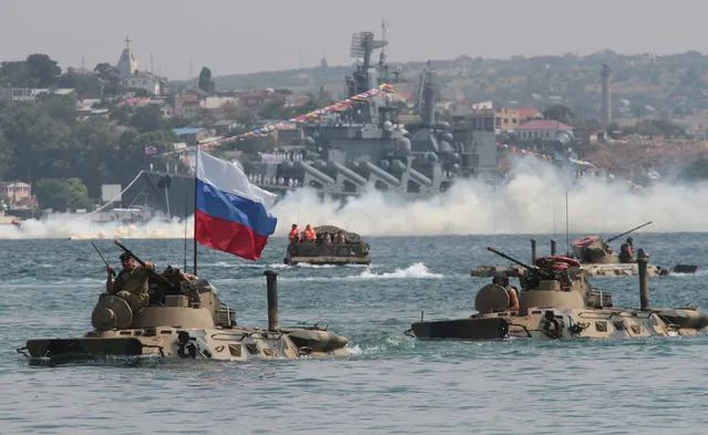 Amphibious vehicles drive in formation past the Russian missile cruiser Moskva during a rehearsal for the Navy Day parade in the Black Sea port of Sevastopol, Crimea, July 27, 2017. (Photo by Pavel Rebrov/Reuters)