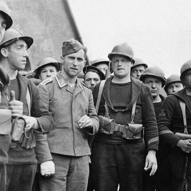 German soldier, prisoner of French, is guarded by French sailors who defended Dunkirk on June 12, 1940. (Photo by AP Photo)