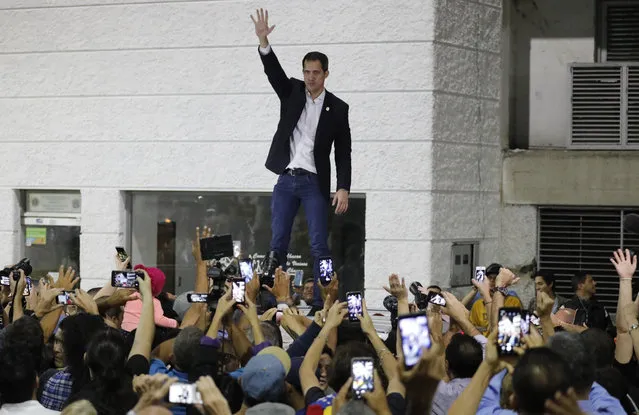 Opposition leader Juan Guaido waves to supporters during a rally at Bolivar Plaza in Chacao, Venezuela, Tuesday, February 11, 2020. Guaido returned home from a tour of nations that back his effort to oust socialist leader Nicolas Maduro. (Photo by Ariana Cubillos/AP Photo)