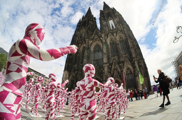 A view of children mannequins wrapped in purple and white barricade tape placed in front of the Cologne Cathedral, installed there by German artist Dennis Josef Meseg, called “Shattered Souls – in a Sea of Silence”, to protest against the abuse scandals in the Catholic Church in Cologne, Germany on August 3, 2023. (Photo by Wolfgang Rattay/Reuters)