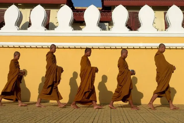 Buddhist monks walk in front of the Royal Palace in Phnom Penh, Cambodia on August 9, 2017. (Photo by Tang Chhin Sothy/AFP Photo)