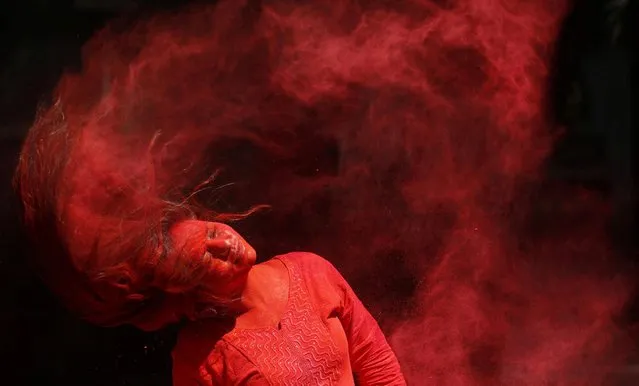 A woman smeared with coloured powder shakes her head to remove it during Holi celebrations in Mumbai, India, March 10, 2020. (Photo by Francis Mascarenhas/Reuters)