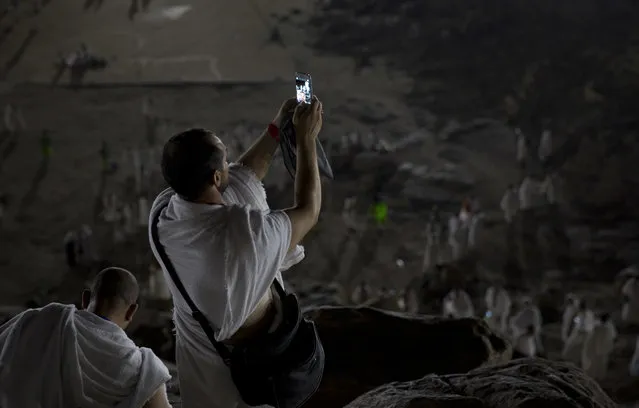 A Muslim pilgrim takes a selfie using his mobile phone, while standing on top of the Jabal Al Rahma holy mountain, or the mountain of forgiveness, upon his arrival to Arafat for the annual hajj pilgrimage, outside the holy city of Mecca, Saudi Arabia, Wednesday, August 30, 2017. (Photo by Khalil Hamra/AP Photo)
