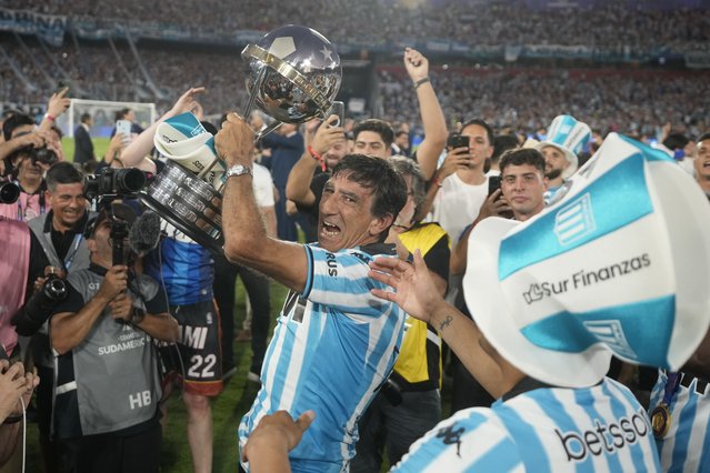 Coach Gustavo Costas of Argentina's Racing Club celebrates with the trophy after winning the Copa Sudamericana final soccer match against Brazil's Cruzeiro in Asuncion, Paraguay, November 23, 2024. (Photo by Jorge Saenz/AP Photo)