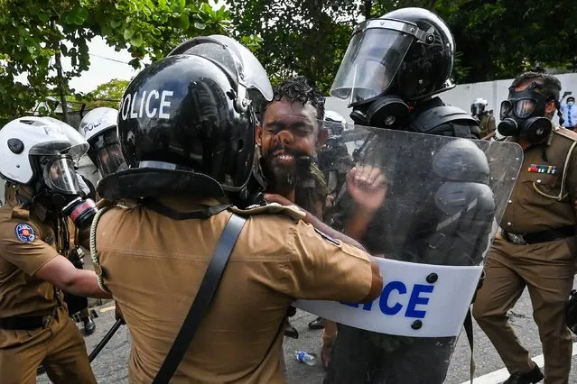 Sri Lankan university students clash with police during a demonstration in Colombo on August 18, 2022. Sri Lanka police fired tear gas and water cannon on a small protest on August 18 to break up the first demonstration since the crisis-hit island nation lifted a state of emergency. (Photo by Ishara S. Kodikara/AFP Photo)
