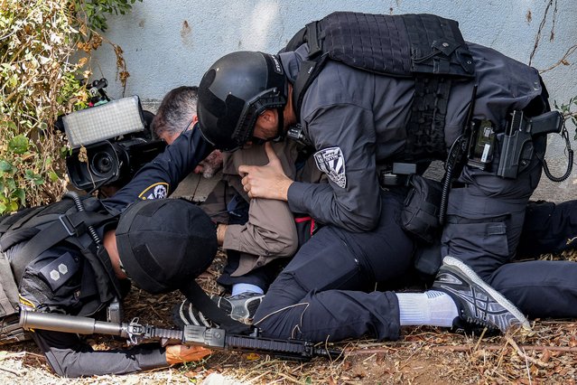 Israeli police and security forces assist a journalist taking cover during an alert for a rocket attack in Israel's southern city of Sderot near the border with Gaza on October 12, 2023. Thousands of people, both Israeli and Palestinians have died since October 7, 2023, after Palestinian Hamas militants based in the Gaza Strip, entered southern Israel in a surprise attack leading Israel to declare war on Hamas in Gaza on October 8. (Photo by Menahem Kahana/AFP Photo)