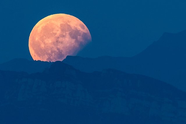 The full moon is seen above the Bernese Alps during a partial lunar eclipse in Bern, Switzerland on August 7, 2017. (Photo by Anthony Anex/European Pressphoto Agency)