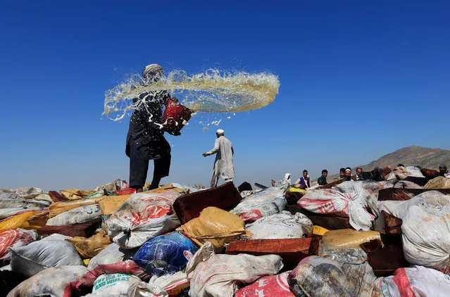 An Afghan man prepares to burn a pile of illegal narcotics on the outskirts of Jalalabad, Afghanistan September 26, 2017. (Photo by Reuters/Parwiz)