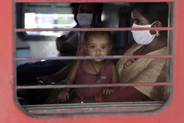 A child looks on as a special train transporting migrant workers to Bihar leaves Thane, in the western Indian state of Maharashtra, Thursday, May 7, 2020. India is running train service for thousands of migrant workers desperate to return home since it imposed a nationwide lockdown to control the spread of the coronavirus. (Photo by Rajanish Kakade/AP Photo)