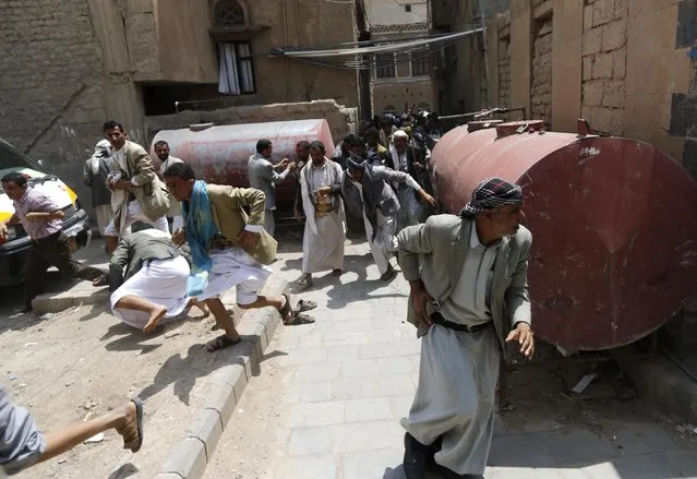 Followers of the Shi'ite Houthi group seek cover as soldiers open fire to disperse them near the cabinet building in Sanaa September 9, 2014. Yemeni soldiers opened fire on Shi'ite Muslim protesters trying to storm the cabinet building in the capital Sanaa on Tuesday, killing at least four, a Reuters photographer and medical sources said. (Photo by Khaled Abdullah/Reuters)