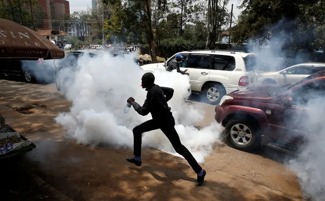 Supporters of Kenyan opposition National Super Alliance (NASA) coalition run after policemen fired tear gas to disperse them during a protest along a street in Nairobi, Kenya October 13, 2017. (Photo by Baz Ratner/Reuters)