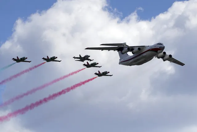 Belarus' IL-76 MD transport aircraft, right, and army jet fighters fly over the city during the Victory Day military parade that marked the 75th anniversary of the allied victory over Nazi Germany, in Minsk, Belarus, Saturday, May 9, 2020. (Photo by Sergei Grits/AP Photo)