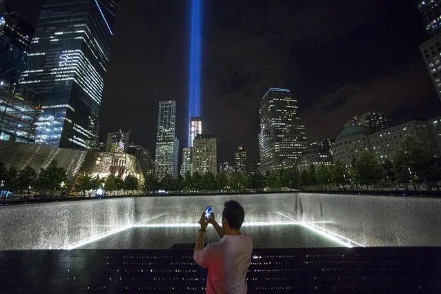 A man takes a photo at the 9/11 Memorial and Museum near the “Tribute in Light” in Lower Manhattan, New York, September 9, 2015. (Photo by Andrew Kelly/Reuters)