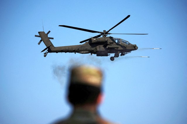 A U.S. soldier looks on at an AH-64E Apache helicopter of the South Korean army firing missiles during a combined live fire drill between South Korea and U.S. army at the Rodriguez Live Fire Complex, in Pocheon, South Korea on October 30, 2024. (Photo by Kim Hong-Ji/Reuters)