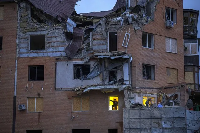 People check the damage at their apartments hit by a Russian missile in Mykolaiv, Sunday, October 23, 2022. (Photo by Emilio Morenatti/AP Photo)