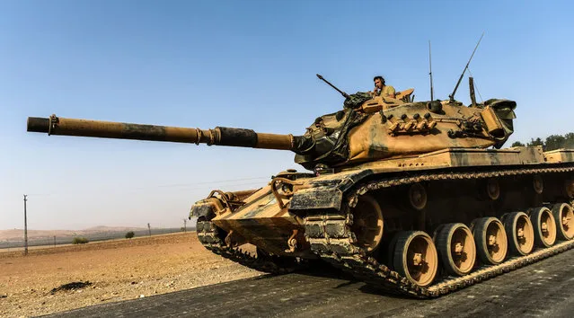 A Turkish army tank drives towards Syria in the Turkish border city of Karkamis, in the southern region of Gaziantep on August 24, 2016. Turkey's army backed by international coalition air strikes launched an operation involving fighter jets and elite ground troops to drive Islamic State jihadists out of a key Syrian border town. (Photo by Bulent Kilic/AFP Photo)